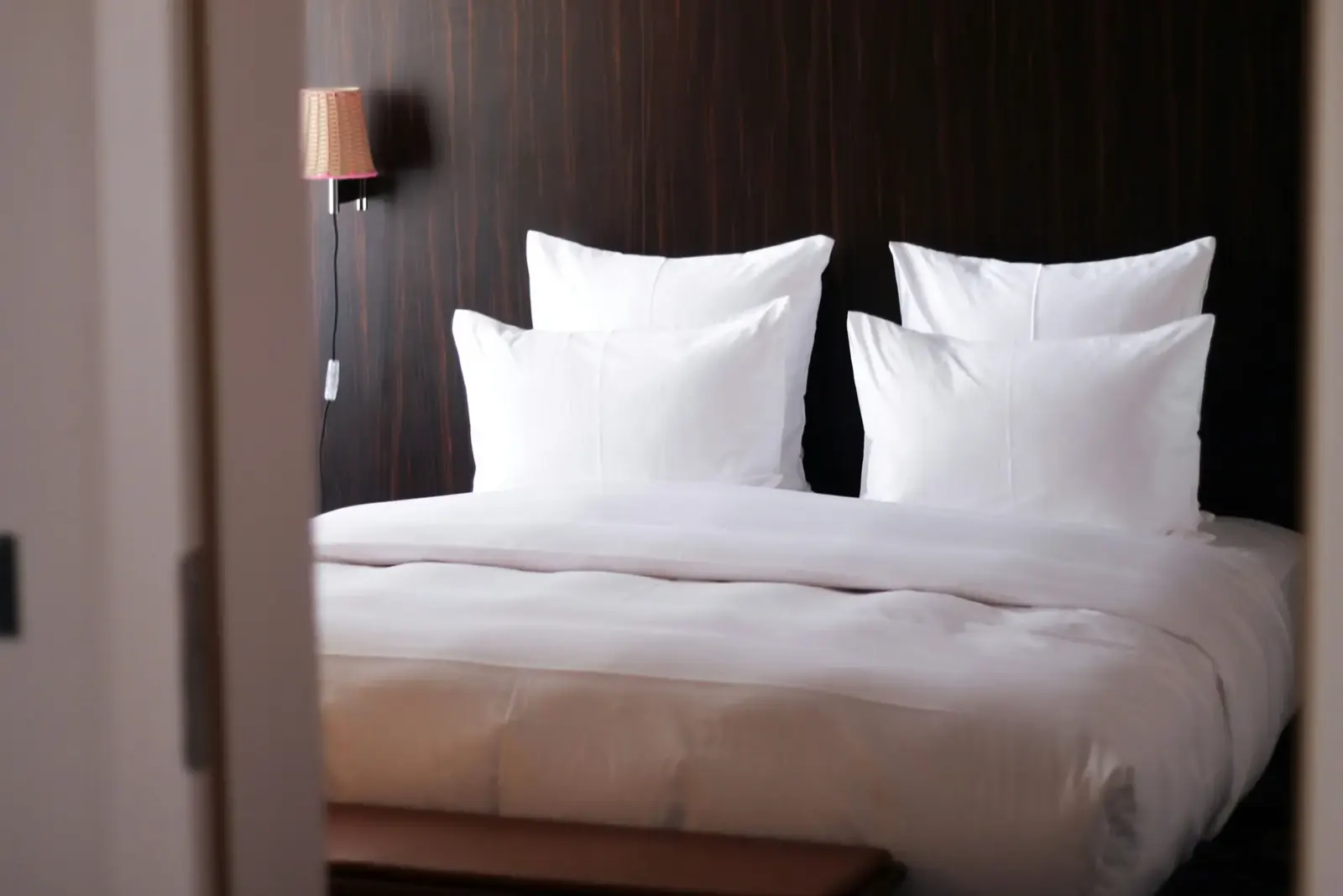 Habitación de hotel con cama blanca y luz cálida